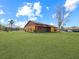 Back exterior view of a home with screened porch and expansive grassy backyard at 713 Green Ct, Kissimmee, FL 34759