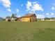 View of the home's exterior, highlighting the yellow siding and large grassy yard at 713 Green Ct, Kissimmee, FL 34759