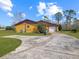 Ranch style home with a large driveway and mature trees at 713 Green Ct, Kissimmee, FL 34759