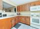 Kitchen with wood cabinets and white appliances at 713 Green Ct, Kissimmee, FL 34759
