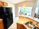Open kitchen with black appliances and view of pool at 8417 Secret Key Cove, Kissimmee, FL 34747