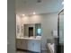 Bright bathroom featuring double sinks, granite countertops, a soaking tub, and a glass-enclosed shower at 853 Ocean Course Ave # 853, Davenport, FL 33896