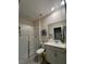 Bathroom features a shower with glass enclosure, single sink vanity, white fixtures, and decorative mirror at 853 Ocean Course Ave # 853, Davenport, FL 33896