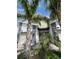 Inviting townhouse exterior features stone accents, a red front door, and lush landscaping with palm trees at 853 Ocean Course Ave # 853, Davenport, FL 33896