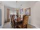 Formal dining room with a wood table, chandelier, and decorative artwork at 8614 La Isla Dr, Kissimmee, FL 34747
