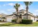 Two-story house with a two-car garage, landscaping, and palm trees at 8614 La Isla Dr, Kissimmee, FL 34747