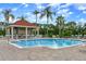 Community pool with a relaxing gazebo and lounge chairs at 8614 La Isla Dr, Kissimmee, FL 34747