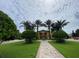 Landscaped entrance to community clubhouse with palm trees at 8968 California Palm Rd, Kissimmee, FL 34747