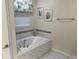 Bright bathroom with a marble-tiled tub, modern faucet, and decorative wall art at 9158 Scramble Dr, Davenport, FL 33896