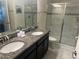 Elegant bathroom with double granite vanity, modern fixtures, and a glass-enclosed shower at 9158 Scramble Dr, Davenport, FL 33896