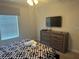 Bright bedroom featuring a geometric patterned comforter and a dresser with mounted tv at 9158 Scramble Dr, Davenport, FL 33896