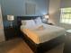 Cozy bedroom with blue accent wall, dark wood furniture and lamps on each side of the bed at 9158 Scramble Dr, Davenport, FL 33896