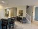 Breakfast bar with granite countertop and seating, complemented by tile flooring and stairs to the upper level at 9158 Scramble Dr, Davenport, FL 33896