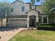 Two-story house with a beige exterior, brown accents, and a brick driveway at 9158 Scramble Dr, Davenport, FL 33896