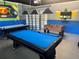 A garage game room designed with foosball and air hockey tables and pool, complete with comfortable seating and playful wall art at 9158 Scramble Dr, Davenport, FL 33896