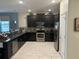Modern kitchen boasting sleek dark cabinetry, stainless steel appliances, granite counters, and stylish backsplash for culinary enthusiasts at 9158 Scramble Dr, Davenport, FL 33896