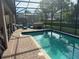 A clear view of the inviting, sparkling pool from the brick-lined patio with lounge chairs and jacuzzi, set against a serene backdrop at 9158 Scramble Dr, Davenport, FL 33896