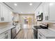 Modern kitchen with stainless steel appliances, white cabinets, and sliding door access to the patio at 927 Mare Bello Dr, Winter Park, FL 32792