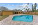 Backyard with a swimming pool featuring brick pavers and the home's exterior with a yellow paint finish at 927 Mare Bello Dr, Winter Park, FL 32792