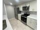 Modern kitchen featuring stainless steel appliances, granite countertops, and white cabinetry at 1014 Plantation Dr # A9, Kissimmee, FL 34741
