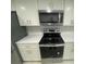 Kitchen area showcasing stainless steel microwave, black range, and white quartz countertop at 1014 Plantation Dr # A9, Kissimmee, FL 34741