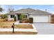 Single-story house with a gray exterior, two-car garage, and well-manicured lawn at 102 Hillcrest Rd, Davenport, FL 33897