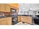 Kitchen with wood cabinets, black appliances, and a mosaic tile backsplash at 102 Hillcrest Rd, Davenport, FL 33897