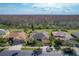 Inviting yellow home featuring a well-manicured lawn, mature landscaping, and a view of the wooded nature preserve behind at 127 Terra Vista Ln, Kissimmee, FL 34759