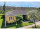 Aerial view of single story home with mature landscaping, a two car garage and view of wooded area at 127 Terra Vista Ln, Kissimmee, FL 34759
