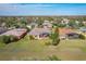 Aerial view of a yellow house featuring a screened-in lanai and lush green lawn at 127 Terra Vista Ln, Kissimmee, FL 34759