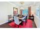 This dining room has an ornate light fixture above a wooden table and red accent rug at 127 Terra Vista Ln, Kissimmee, FL 34759