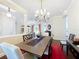 This dining room has an ornate light fixture, wood table, red rug, and overlooks the living room and kitchen at 127 Terra Vista Ln, Kissimmee, FL 34759
