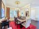 This dining room has an ornate light fixture above a wooden table, a red accent rug, and shuttered windows at 127 Terra Vista Ln, Kissimmee, FL 34759