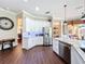 Open kitchen with white cabinets, stainless steel appliances, granite countertops, and adjacent dining and living areas at 127 Terra Vista Ln, Kissimmee, FL 34759