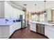 An open kitchen with white cabinets, granite countertops, stainless steel appliances, and views to dining area at 127 Terra Vista Ln, Kissimmee, FL 34759