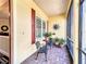 Cozy screened-in front porch with brick flooring, outdoor seating, and views of the landscaped yard at 127 Terra Vista Ln, Kissimmee, FL 34759