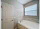 Relaxing bathroom with soaking tub, tile flooring, and updated fixtures at 1404 Lexington Avenue, Davenport, FL 33837