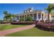 Beautiful clubhouse exterior featuring a covered veranda with pillars, lush lawn and decorative landscaping at 1404 Lexington Avenue, Davenport, FL 33837