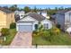 Charming single-story home with a well-maintained lawn, garden beds, and a gray two-car garage at 1404 Lexington Avenue, Davenport, FL 33837