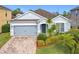 Traditional-style home with a two-car garage, well-manicured lawn and garden beds at 1404 Lexington Avenue, Davenport, FL 33837