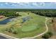 Aerial view of a picturesque golf course featuring water hazards, winding cart paths, and tree-lined fairways at 1404 Lexington Avenue, Davenport, FL 33837
