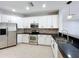 Bright kitchen featuring white cabinets, stainless steel appliances, and dark countertops at 1404 Lexington Avenue, Davenport, FL 33837