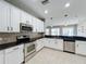 Modern kitchen featuring stainless steel appliances, white cabinets, and a stylish tile backsplash at 1404 Lexington Avenue, Davenport, FL 33837