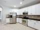 Modern kitchen with stainless steel appliances and white cabinets at 1404 Lexington Avenue, Davenport, FL 33837