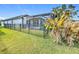 A beautiful screened in pool surrounded by a black metal fence and lush green grass at 1404 Lexington Avenue, Davenport, FL 33837