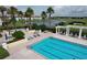 Relaxing pool area with sun loungers, umbrellas, manicured landscaping, and serene lake views at 1404 Lexington Avenue, Davenport, FL 33837