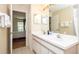 Well-lit bathroom featuring double sinks, white cabinetry, and a separate toilet room at 143 Hollingshead Loop, Davenport, FL 33896