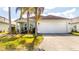 Charming single-story home with well-maintained landscaping and a two-car garage at 143 Hollingshead Loop, Davenport, FL 33896