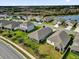 Aerial view of homes in a suburban neighborhood, bordering a lush green forest and pond at 1813 Castleton Dr, St Cloud, FL 34771
