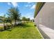 Backyard view of screened lanai with beautifully landscaped lawn and surrounding street view at 1813 Castleton Dr, St Cloud, FL 34771
